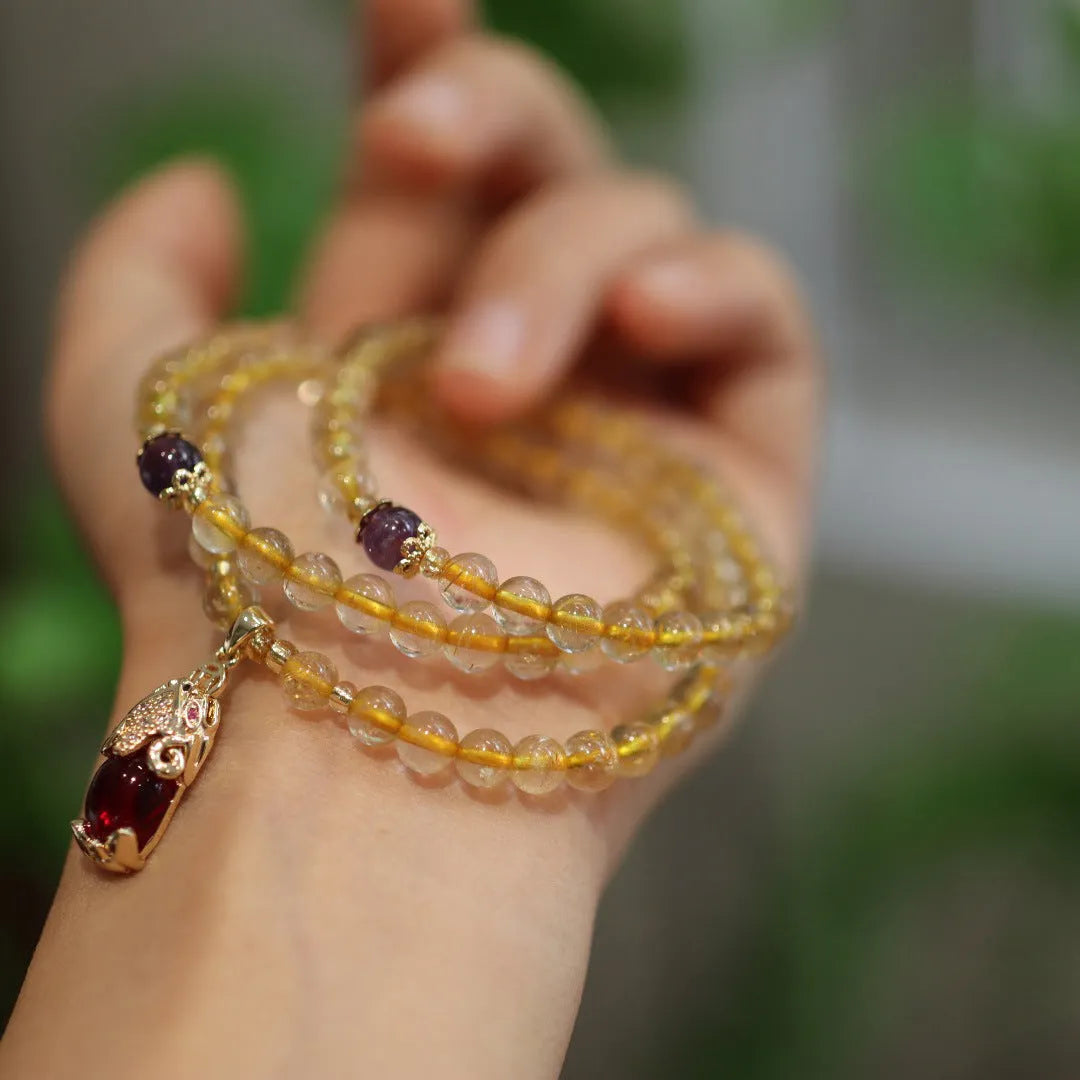 Close-up of a natural gold rutilated quartz bracelet with a Chinese style three-circle design.