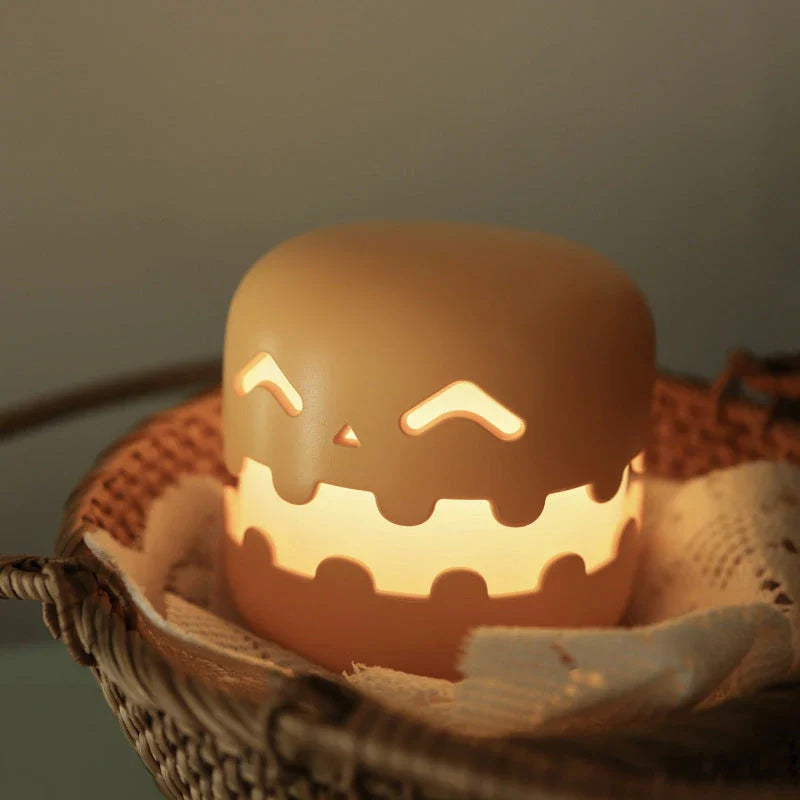 Pumpkin-shaped nightlight with soft silicone construction and warm, soothing glow for creating a cozy Halloween atmosphere