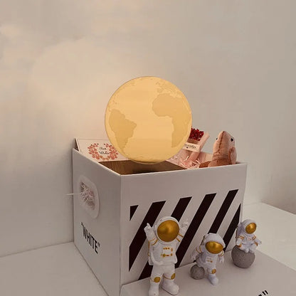 Maglev floating night light with glowing moon and planet designs on a table.