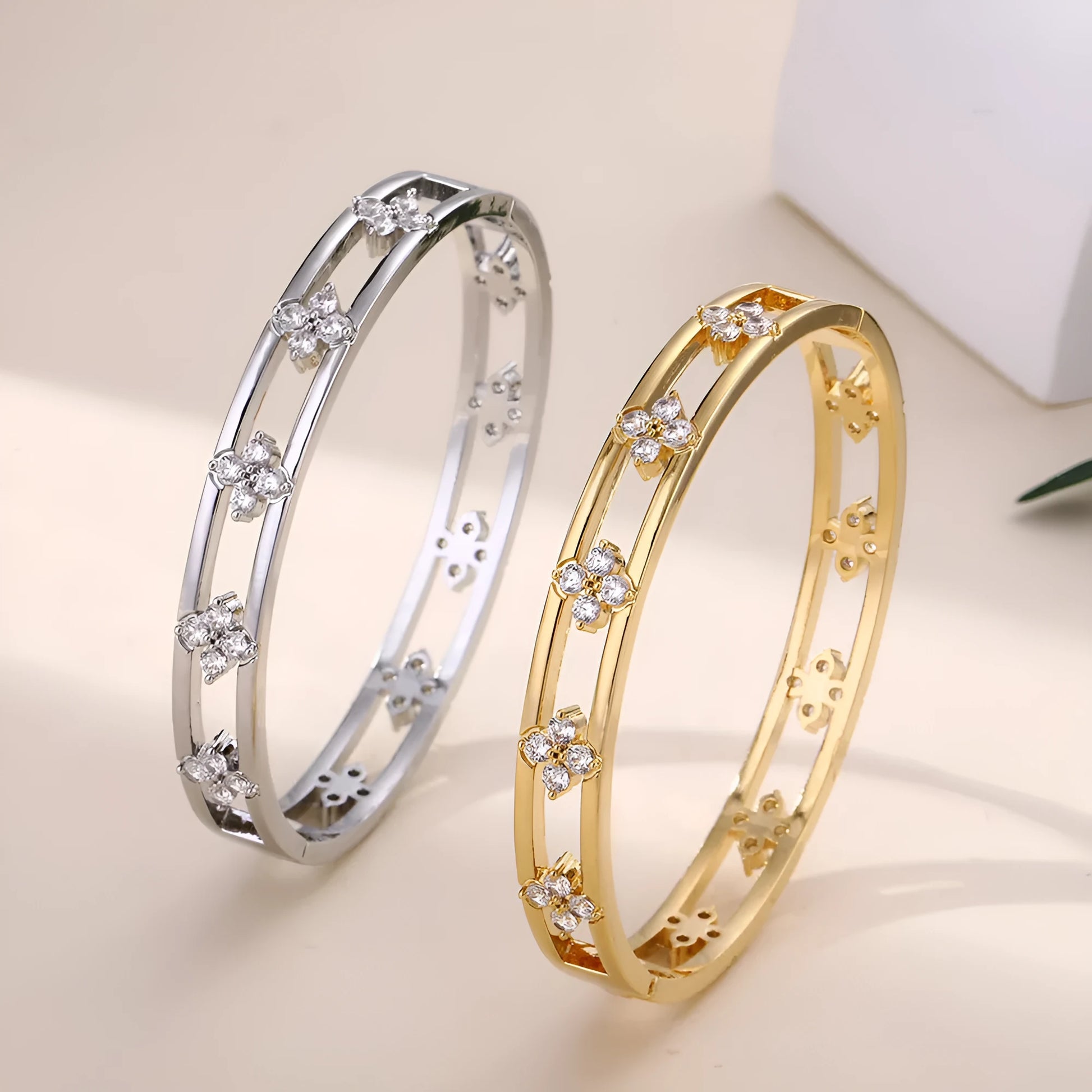 Hollow women's bracelet with four-leaf clover design and inlaid zircon stones in gold or silver finish.
