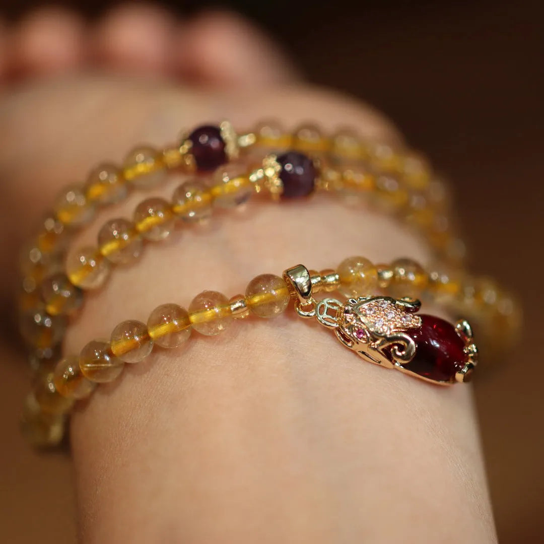 Close-up of a natural gold rutilated quartz bracelet with a Chinese style three-circle design.