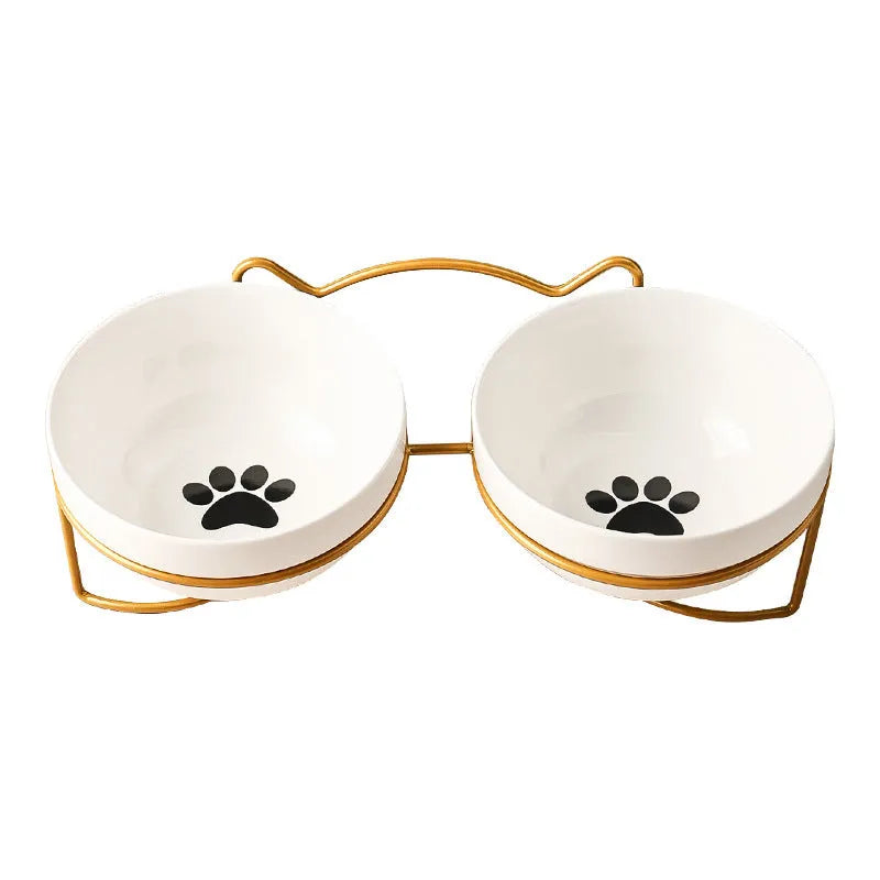 White ceramic pet bowl with cat paw design on a black iron frame raised feeder.