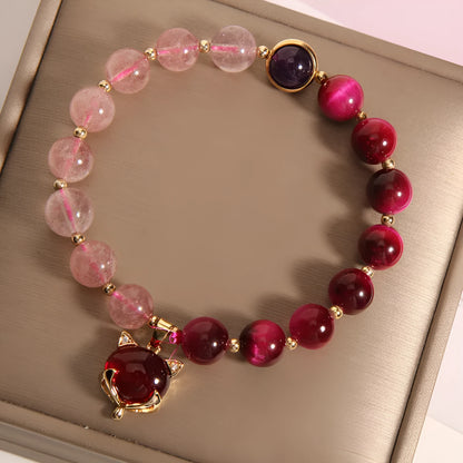 Simple women's bracelet with a red strawberry crystal charm on a black elastic rope.