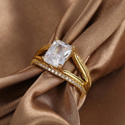 Gold electroplated geometric ring with a square zircon stone on a copper band.