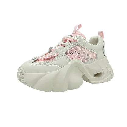 Women's pink sneakers with cross straps, thick sole, and mesh lining on a white background