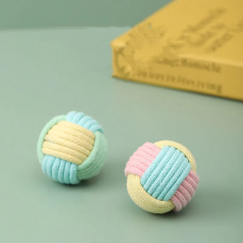 Handmade blue and pink cotton plush ball cat toy, 5cm in diameter, on a wooden floor.