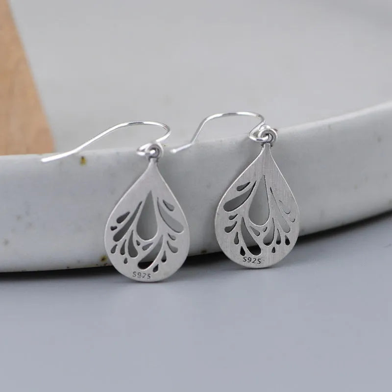 Retro hollow water drop shaped earrings in 925 silver with a textured grinding finish.