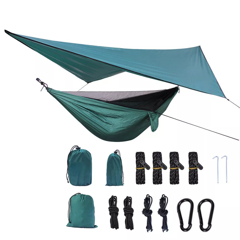 Portable camping hammock with mosquito net and awning setup in a forest