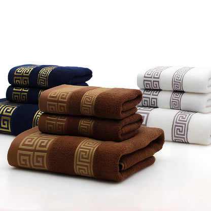 Three-piece cotton towel set showing 70cm bath towel and two 34cm hand towels in white, dark blue, and brown colours