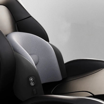 Black car massage cushion with adjustable straps attached to a car seat headrest