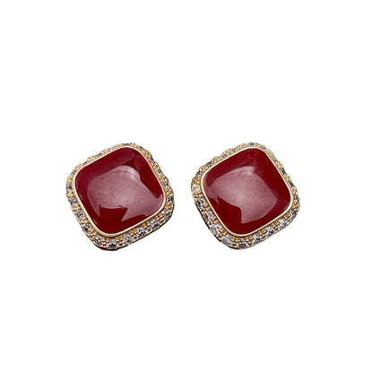 Red square alloy earrings with an inlaid geometric design, shown from the front.