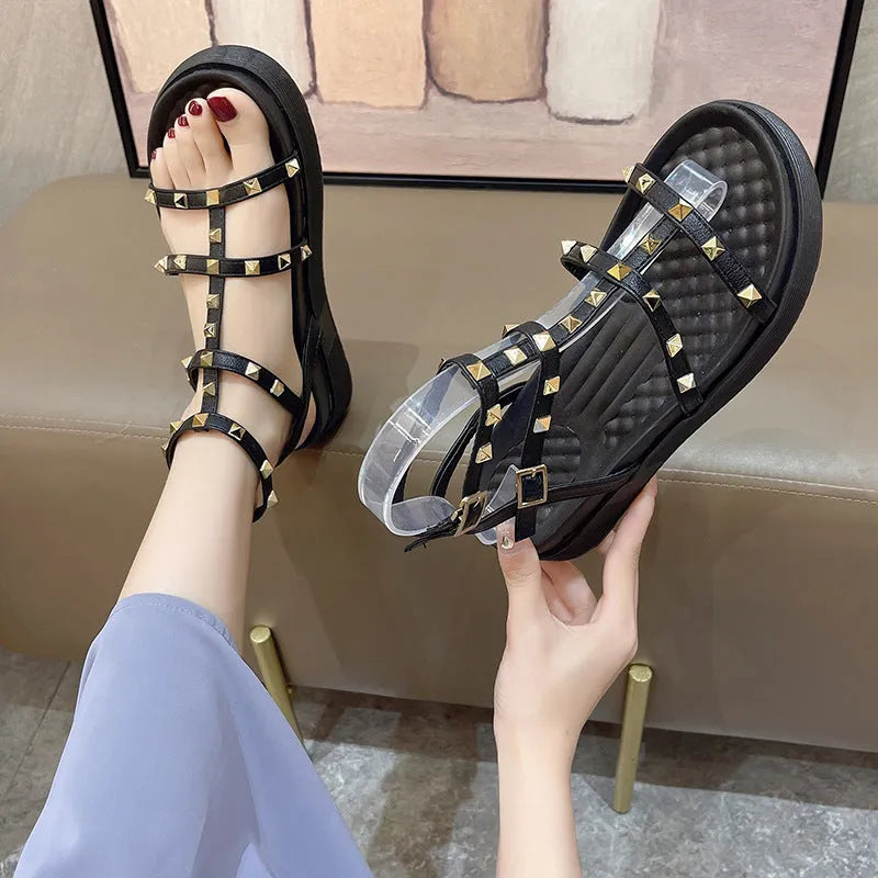 Women's Roman-style flat sandals with round toe, rivet platform, ankle buckle, PU upper, rubber sole, beige or black.