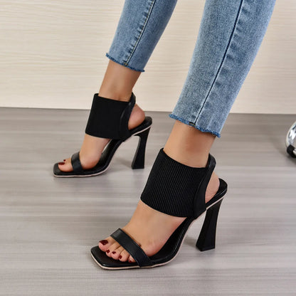 Black high heel sandals for women with criss-cross elastic straps and a rubber sole.