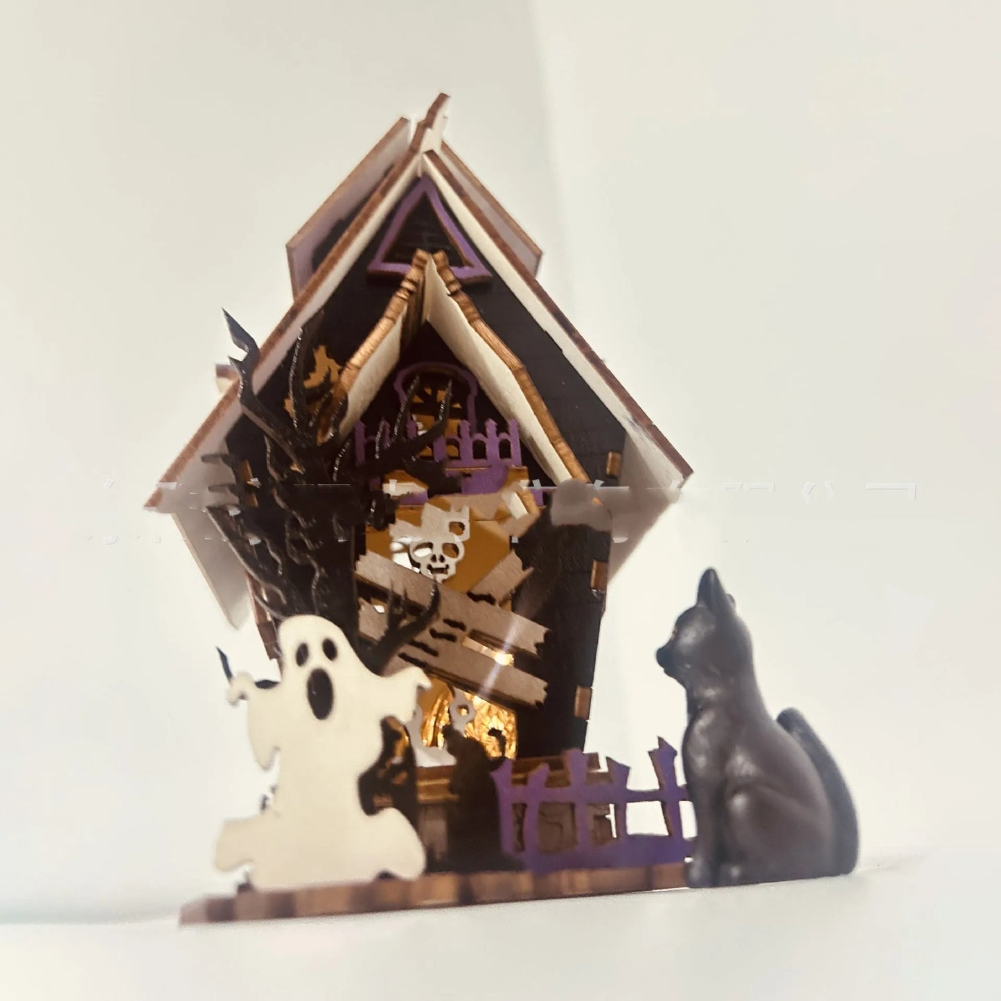 Wooden haunted house table decoration measuring 14x10.5x19cm with luminous finish and candlestick holder function