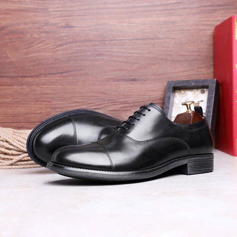 A pair of men's shoes made from premium cowhide with a gradient upper design and lace-up closure