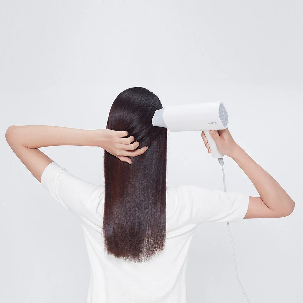 Compact, portable hair dryer with foldable handle and multiple styling settings for on-the-go hair care.