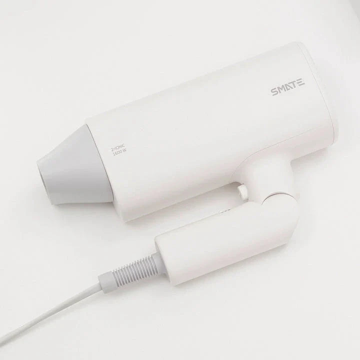 Compact, portable hair dryer with foldable handle and multiple styling settings for on-the-go hair care.