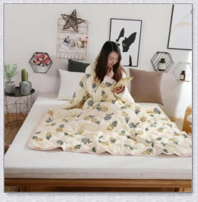 A cozy, wearable lazy quilt with sleeves in gray, providing hands-free warmth and comfort for relaxation and outdoor activities.