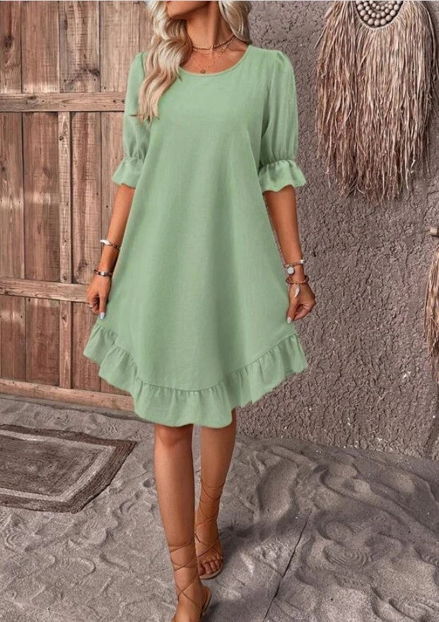 A women's summer dress with a ruffle detail and a loose, straight silhouette in a solid color