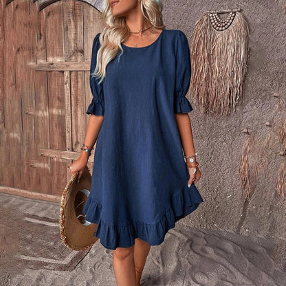A women's summer dress with a ruffle detail and a loose, straight silhouette in a solid color