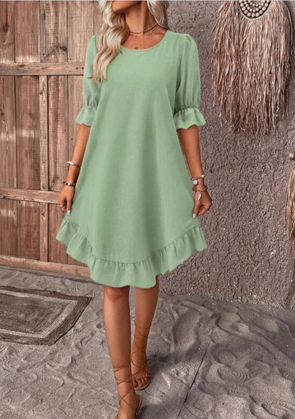 A women's summer dress with a ruffle detail and a loose, straight silhouette in a solid color