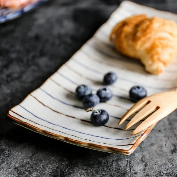 Japanese-inspired ceramic plate with blue and orange color design, featuring a gently curved shape for enhanced presentation of meals.