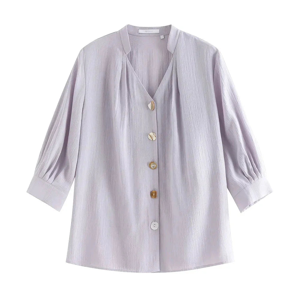 Photograph of a women's French V-neck loose, cozy style shirt in a creamy-white color