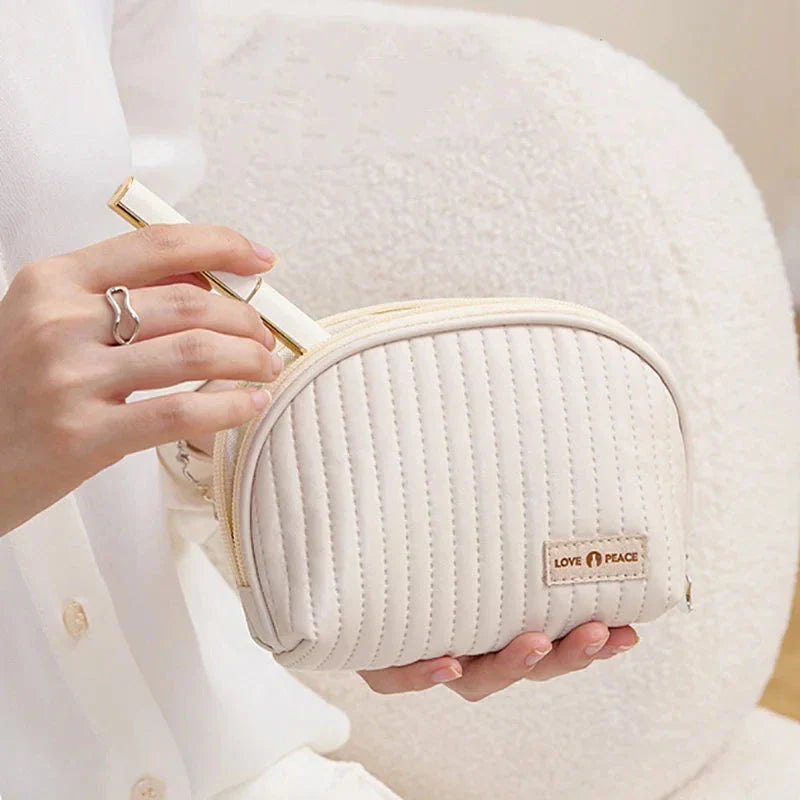Stylish compact makeup bag made of premium PU leather in light blue color, with a sleek minimalist design for modern women