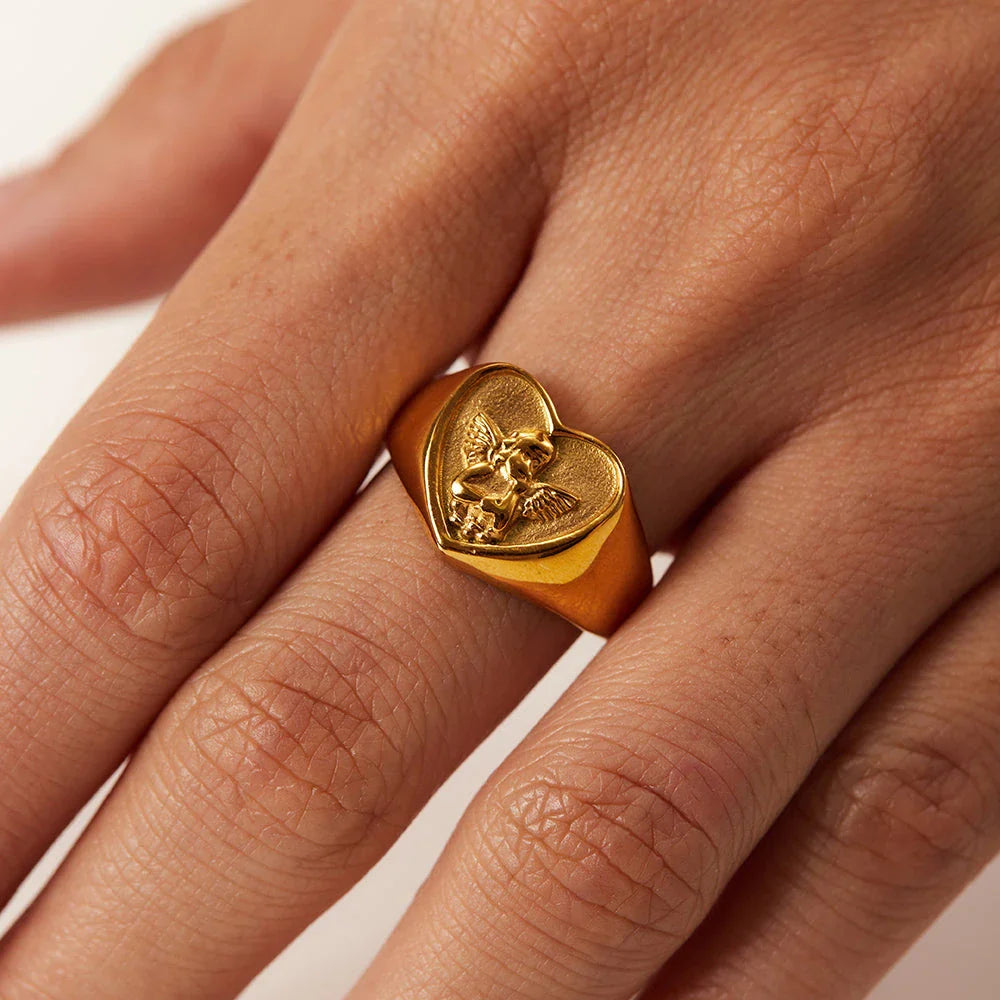 Sophisticated gold-plated stainless steel ring with a geometric heart and angel design, perfect for adding a touch of elegance to any outfit.