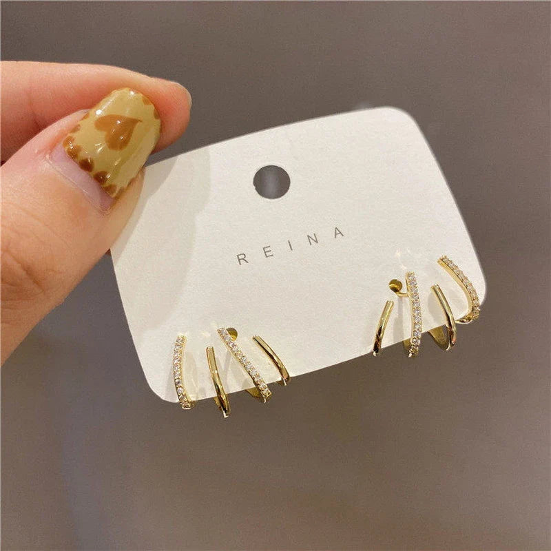 Elegant gold-toned zircon four-claw stud earrings with a classic cuff design, offering a sparkling and sophisticated look.