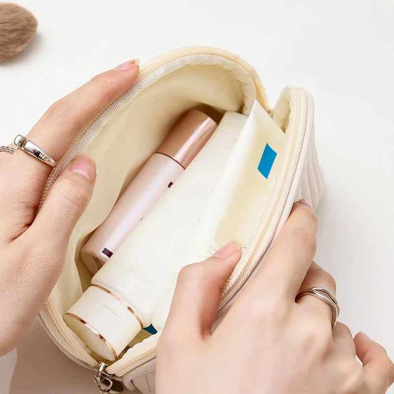 Stylish compact makeup bag made of premium PU leather in light blue color, with a sleek minimalist design for modern women