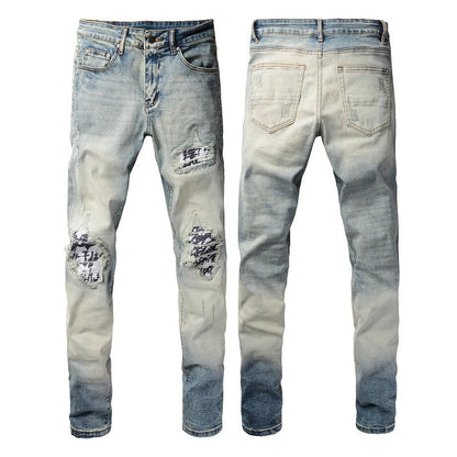 American High Street fashionable men's ripped black and white patch jeans in a light blue denim color