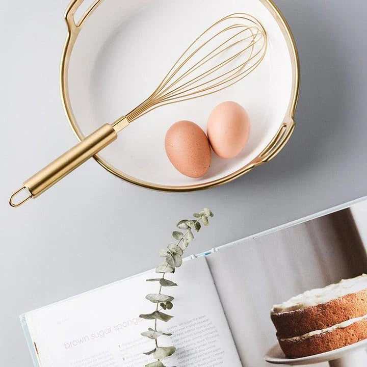 A gold baking tool set including a whisk, scraper, and flour cup made of high-quality stainless steel for versatile and elegant baking needs.