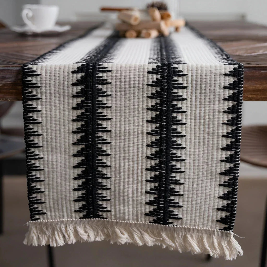 Elegant black and white cotton table runner with striped pattern and tassels, perfect for sophisticated dining experiences