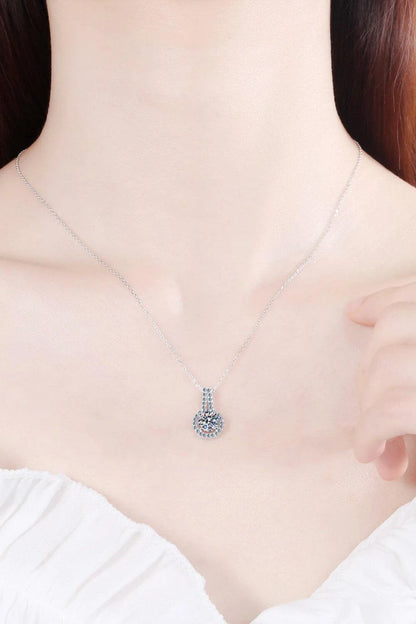 A sterling silver necklace with a round moissanite stone pendant, showcasing a sparkling and elegant design.
