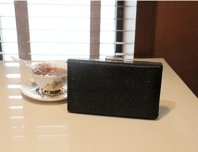 A shiny, metallic dinner clutch bag with a detachable chain strap for versatile carrying options