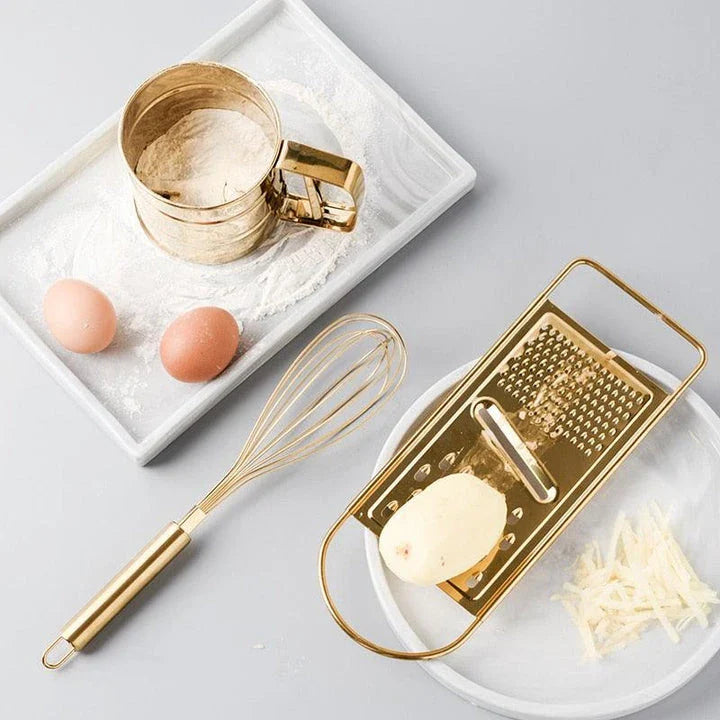 A gold baking tool set including a whisk, scraper, and flour cup made of high-quality stainless steel for versatile and elegant baking needs.