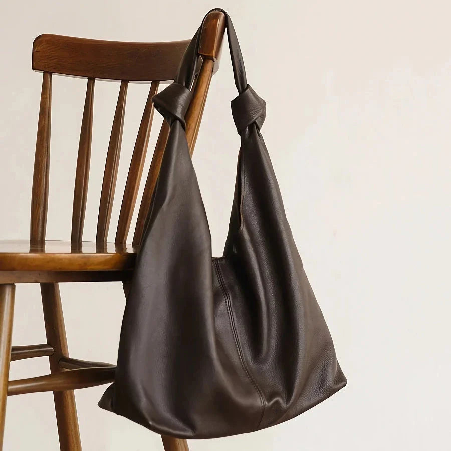 Luxurious oversized genuine leather hobo shoulder bag in black, featuring a spacious interior, multiple compartments, and a soft, flexible design for everyday use.