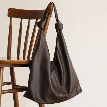 Luxurious oversized genuine leather hobo shoulder bag in black, featuring a spacious interior, multiple compartments, and a soft, flexible design for everyday use.