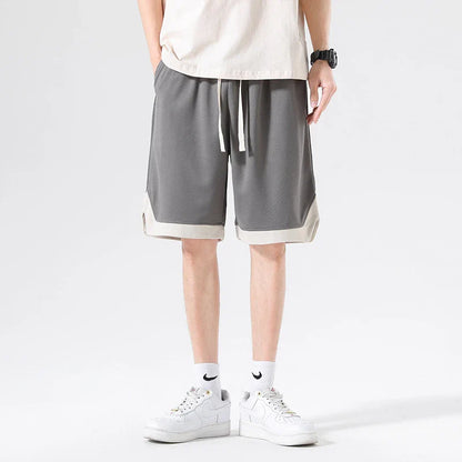 Men's loose and comfortable sports pirate shorts in white, gray, and black colors with elasticized waistband and relaxed fit
