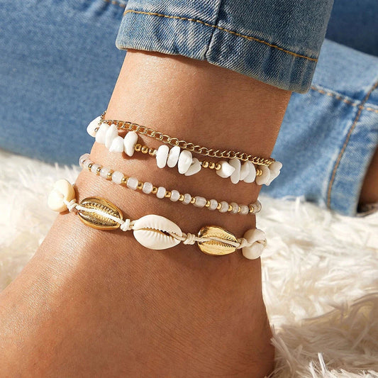 A pair of boho-inspired anklets adorned with natural shells and crushed stones, showcasing a unique geometric design for effortless summer style.