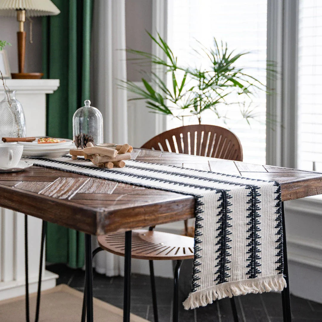Elegant black and white cotton table runner with striped pattern and tassels, perfect for sophisticated dining experiences