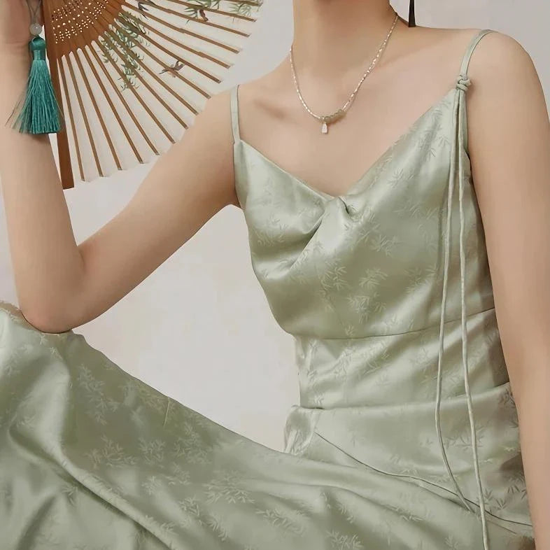 Elegant mint green midi dress with spaghetti straps, featuring a slim fit and intricate embroidery details