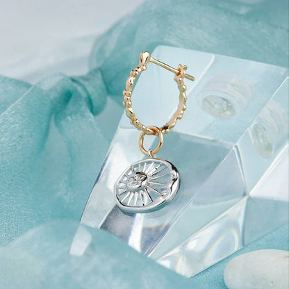 Elegant silver earrings with a geometric sun and moon design, perfect for adding a touch of celestial style to any outfit.