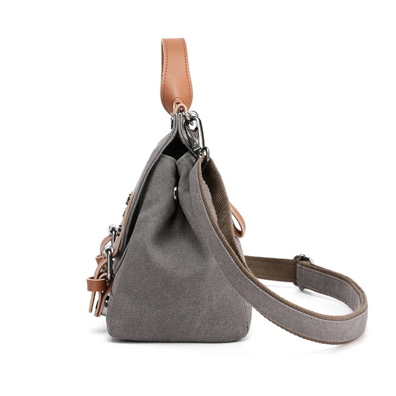 A stylish women's canvas crossbody handbag in an orange color, featuring a small square shape and a horizontal design.