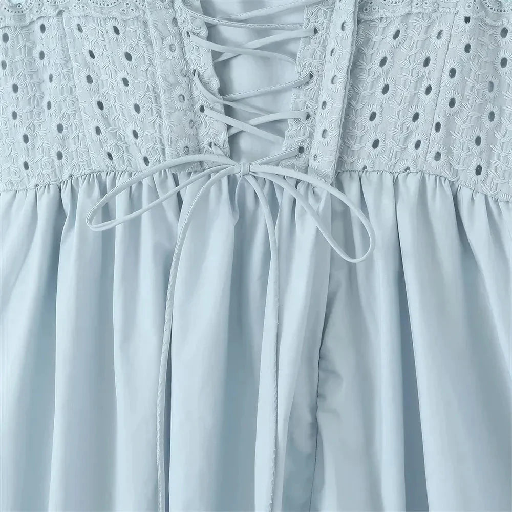 A stylish blue midi crochet dress with a floral pattern and spaghetti straps, perfect for summer occasions.