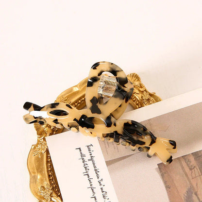 Elegant leopard print large weave hair clip for women and girls, made with durable acrylic and alloy materials for a secure and comfortable hold.