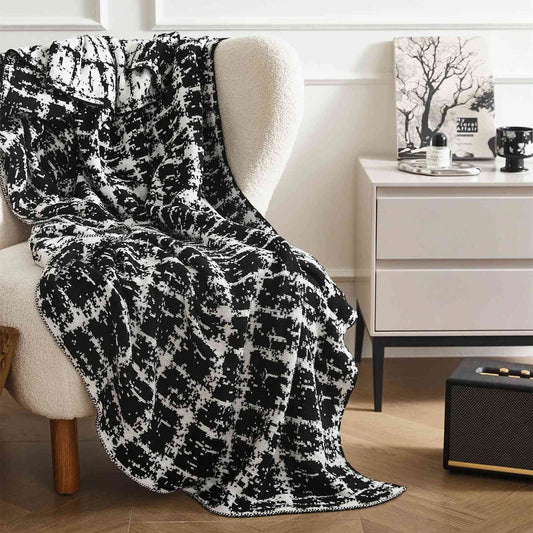 Luxurious white and black plaid wool knit blanket for cozy home, travel, and relaxation