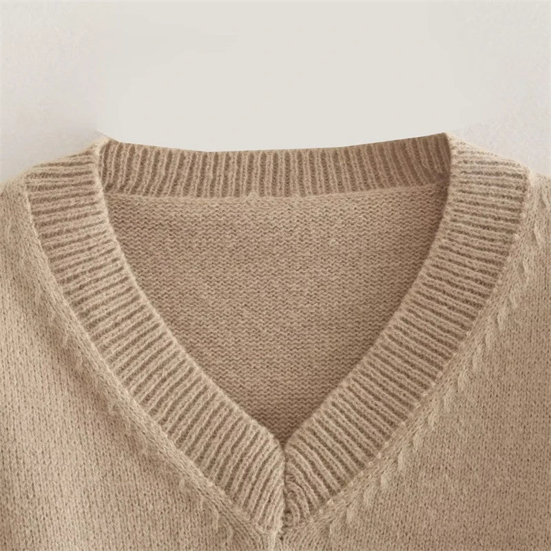 A cozy, knitted pullover sweater with a timeless round neck design, available in a versatile camel color.