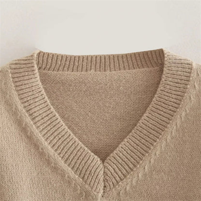 A cozy, knitted pullover sweater with a timeless round neck design, available in a versatile camel color.